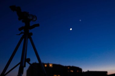 Alacakaranlık gökyüzü ile astronomi teleskopunun silueti.