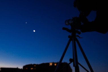 Silhouette of a astronomy telescope and amateur astronomer with stars on the sky. clipart