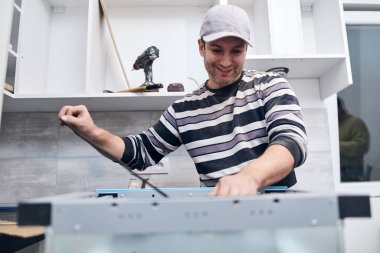 Tamirci işçi ev mobilyalarını tamir edip monte ediyor..