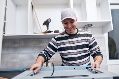 Tamirci işçi ev mobilyalarını tamir edip monte ediyor..