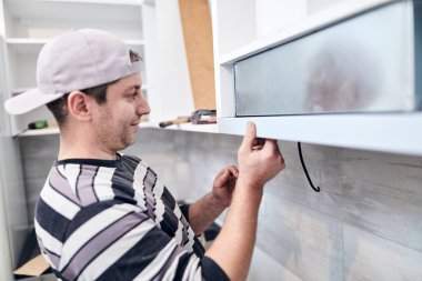 Tamirci işçi ev mobilyalarını tamir edip monte ediyor..