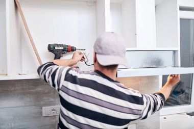 Tamirci mobilya montajı yapıyor ve tamir ediyor..