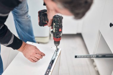 Tamirci mobilya montajı yapıyor ve tamir ediyor..