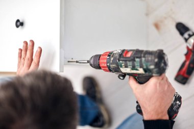 Tamirci mobilya montajı yapıyor ve tamir ediyor..