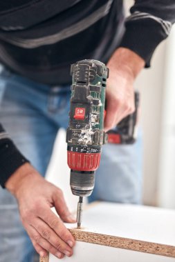 Tamirci mobilya montajı yapıyor ve tamir ediyor..