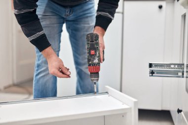 Tamirci mobilya montajı yapıyor ve tamir ediyor..