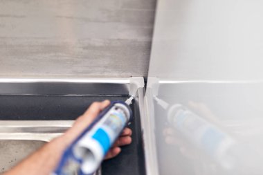 Tamirci, ev eşyaları için silikon dolgu macunu yapıştırıcısı kullanıyor..