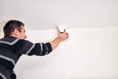 Elektrikçi evde kabloları ve elektrik tesisatını tamir ediyor..