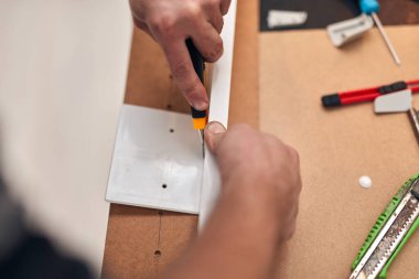 Ev eşyaları için neşter kesici kullanan bir tamirci..