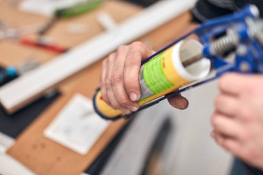 Tamirci, ev eşyaları için silikon dolgu macunu yapıştırıcısı kullanıyor..