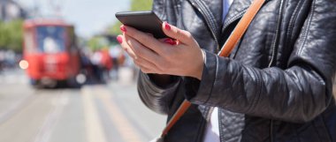 Avrupa 'da bir tramvay istasyonunda cep telefonu kullanan bir kadın..