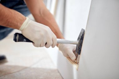 Genç yetişkin bir adam yeni evinin DIY bütçe tadilatı üzerinde çalışıyor..