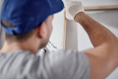 Genç yetişkin bir adam yeni evinin DIY bütçe tadilatı üzerinde çalışıyor..