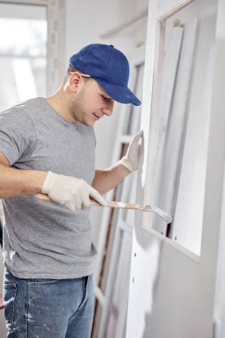 Genç yetişkin bir adam yeni evinin DIY bütçe tadilatı üzerinde çalışıyor..