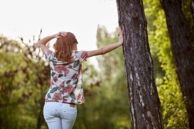 Parktaki kadın kendini mutlu ve güçlü hissediyor..