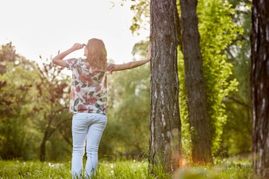 Parktaki kadın kendini mutlu ve güçlü hissediyor..