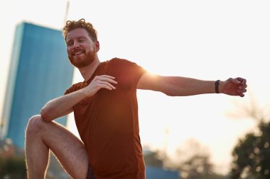 Parktaki bankta gerinen sporcu adam..