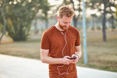 Şehir parkında spor yapan genç bir adam..