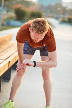 Şehir parkında spor yapan genç bir adam..