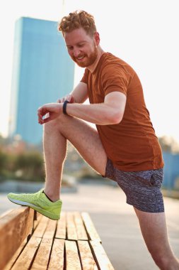 Parktaki bankta gerinen sporcu adam..