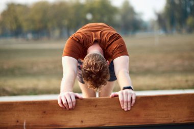 Parktaki bankta şınav çeken sporcu..