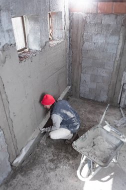 Yeni evin içindeki duvarda çalışan gerçek bir inşaat işçisi..