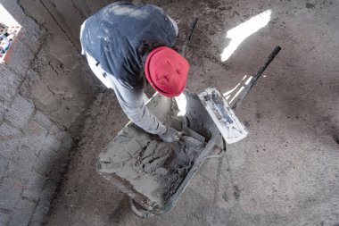 Yeni evin içindeki duvarda çalışan gerçek bir inşaat işçisi..