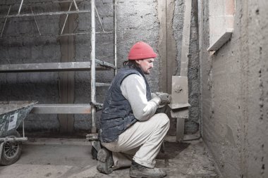 Yeni evin içindeki duvarda çalışan gerçek bir inşaat işçisi..