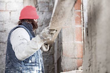 Yeni evin içindeki duvarda çalışan gerçek bir inşaat işçisi..