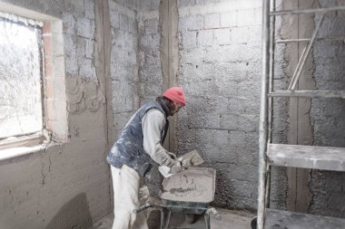 Yeni evin içindeki duvarda çalışan gerçek bir inşaat işçisi..