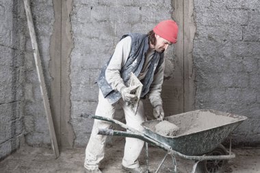 Yeni evin içindeki duvarda çalışan gerçek bir inşaat işçisi..