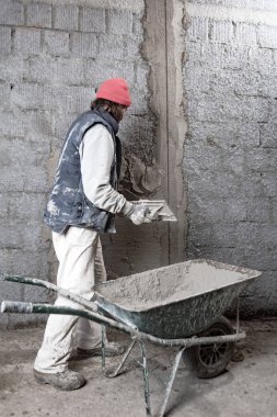 Yeni evin içindeki duvarda çalışan gerçek bir inşaat işçisi..