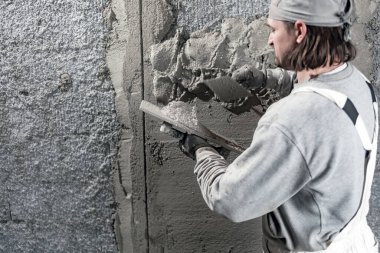Yeni evin içindeki duvarda çalışan gerçek bir inşaat işçisi..