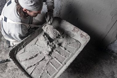 Yeni evin içindeki duvarda çalışan gerçek bir inşaat işçisi..