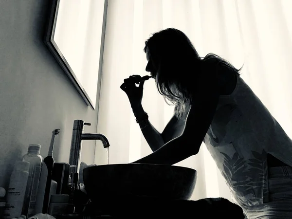 Mujer Usando Cepillo Dientes Baño Iluminado — Foto de Stock
