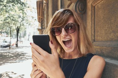 Sokakta modern akıllı telefon kullanan bir kadın..