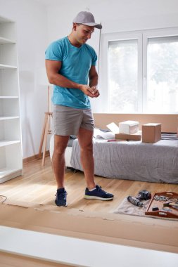 Tamirci yeni dairede mobilya montajı yapıyor, taşınıyor ve çok çalışıyor..