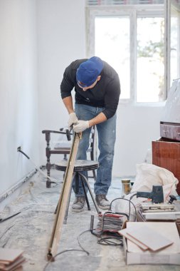 Genç yetişkin bir adam yeni evinin DIY bütçe tadilatı üzerinde çalışıyor..