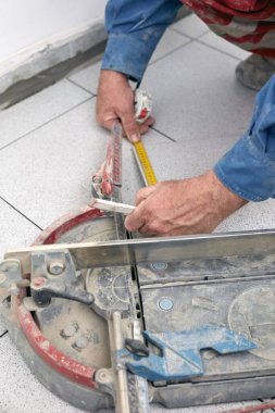 Profesyonel seramik fayans işçisi yere ve duvara yeni fayanslar yerleştiriyor..