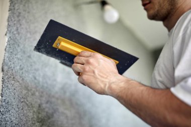 Adam evin ön cephesinde çalışıyor..