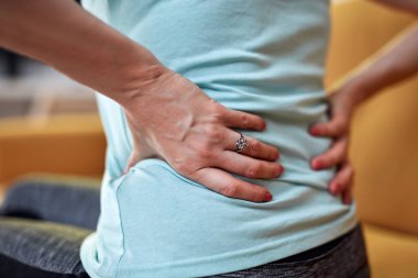 Sırtı ve kalçası ağrıyan bir kadın..