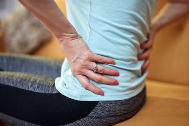 Sırtı ve kalçası ağrıyan bir kadın..