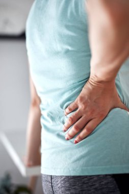 Sırtı ve kalçası ağrıyan bir kadın..