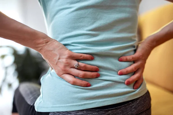 Woman with back and hip pain at home.