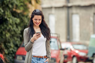 Sokakta smatrphone kullanan genç ve tatlı bir kadın..