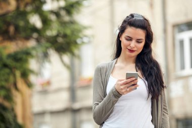 Sokakta smatrphone kullanan genç ve tatlı bir kadın..