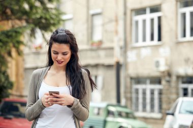 Sokakta smatrphone kullanan genç ve tatlı bir kadın..