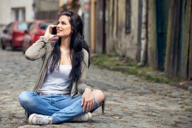 Sokakta smatrphone kullanan genç ve tatlı bir kadın..