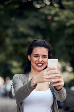 Sokakta smatrphone kullanan genç ve tatlı bir kadın..