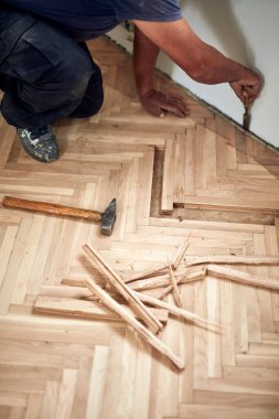 Tamirci eski parke döşemesini restore ediyor..